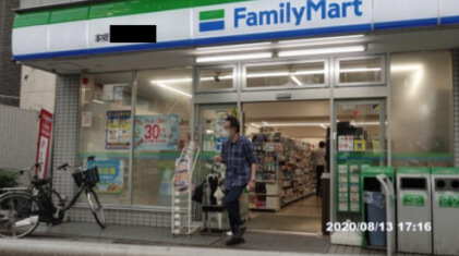 コンビニエンスストアから出てきた男性の写真