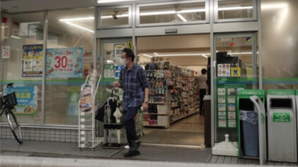 コンビニエンスストアから出てきた男性の写真